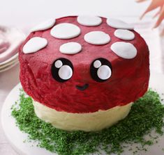 a red and white cake on a plate with green sprinkles around it