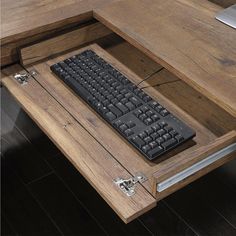 a wooden desk with a keyboard and mouse in it on top of a wood floor