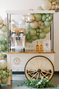 an old fashioned cart with balloons on the side and a bunch of greenery behind it