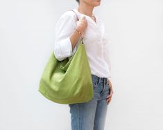 "Lovely lime green hobo bag in stonewashed linen with leather strap, perfect for summer. It is a very comfy shoulder bag, oversized but very lightweight. Also, the wide leather strap does not stick to your shoulder. This shoulder bag is lined with a lime and white striped fabric 100% cotton. Its 100% linen outer fabric is very cool and pleasant for the summer. This hobo bag is perfect for any time of day and adds style to any outfit. * Materials: - Outside: 100% stonewashed linen. Lime green col Spring Green Canvas Shoulder Bag, Green Canvas Shoulder Bag For Spring, Summer Linen Shoulder Bag For Everyday Use, Versatile Green Hobo Bag, Everyday Green Hobo Bag With Adjustable Strap, Green Canvas Hobo Tote Bag, Green Canvas Tote Hobo Bag, Green Hobo Bag For Spring Travel, Versatile Green Canvas Bag