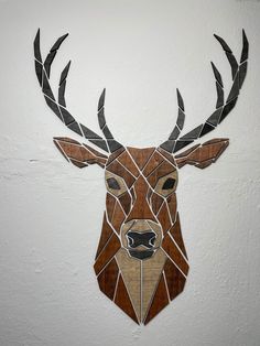 a deer head made out of stained glass on a white wall with black and brown accents