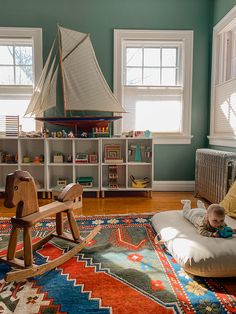 a child's room with a rocking chair and toy sailboat on the wall