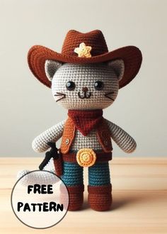 a crocheted cat wearing a cowboy hat and holding a small keychain