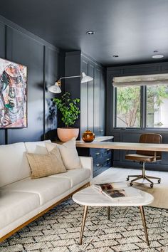 a living room filled with furniture and a painting on the wall next to a window