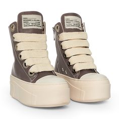 The sneakers are high-top platform-style shoes with a dominant color scheme of chocolate and cream. They feature a thick, cream-colored rubber sole with layered detailing that gives the shoe a bold and chunky silhouette. The upper part of the sneakers is primarily chocolate, constructed with leather material. The design includes metal eyelets for the laces, which are cream-colored and chunky, complementing the sole. Christian Zerotre, Chunky Tennis Shoes, Doctor Shoes, Chunky Platform Shoes, Curvy Casual Outfits, Creative Shoes, Pretty Shoes Sneakers, Shoes Outfit Fashion, Chocolate Leather