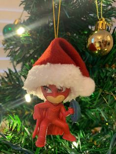 an ornament hanging from a christmas tree in the shape of a santa hat