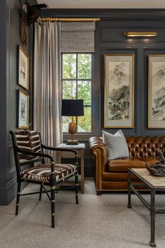 a living room filled with furniture and paintings on the wall