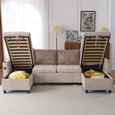 a living room with a couch, ottoman and two pillows on the floor next to each other