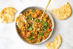 a bowl filled with food next to crackers on top of a white countertop