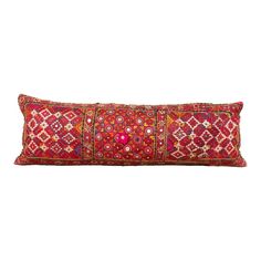 a red and pink decorative pillow on a white background