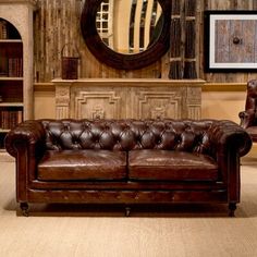 a brown leather couch sitting in front of a mirror