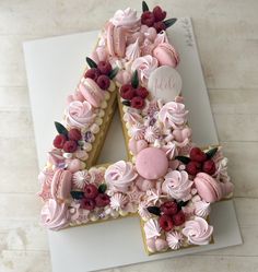 a cake shaped like the number four is decorated with flowers and icing on top of a sheet of paper