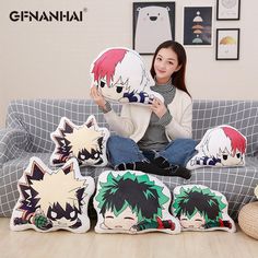 a woman sitting on a couch holding up some pillows with anime character faces printed on them