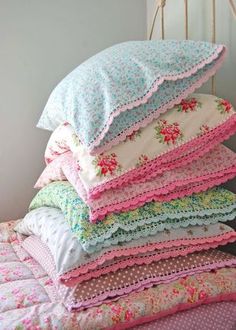 a stack of pillows sitting on top of a bed