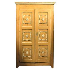 an antique wooden armoire with decorative carvings on the front and sides, painted yellow