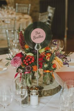 the table is set up with flowers and wine glasses for guests to sit down at