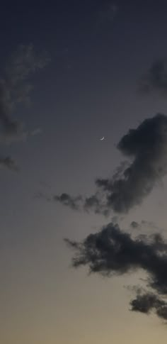 an airplane is flying in the sky at night with a moon and clouds behind it