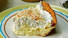 a piece of pie with whipped cream on top sits on a green and blue plate