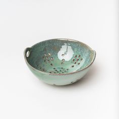 a small green bowl with holes in it