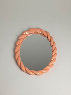 a round mirror that is made out of wood and has a twisted rope around it