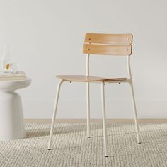 a white toilet sitting next to a wooden chair on top of a carpeted floor