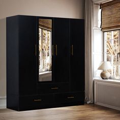 a black armoire sitting next to a window