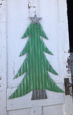 a green christmas tree painted on the side of a white door with a star hanging from it