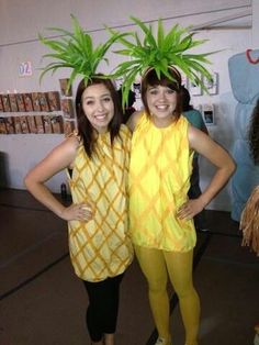 two women in costumes standing next to each other with plants on their heads and legs