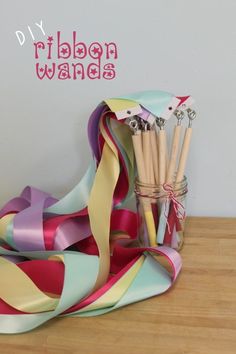 ribbons and pencils in a jar on a table with the words diy ribbon wands