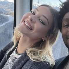 a man and woman smile as they ride on a cable car