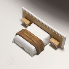 there is a miniature bed with wooden headboard and foot board attached to the wall