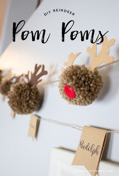 some paper reindeer decorations hanging on a wall with the words pom poms attached to it