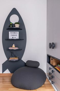 a room that has some shelves on the wall and a bean bag chair in front of it