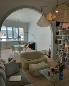 a living room filled with furniture and lots of bookshelves on top of a hard wood floor