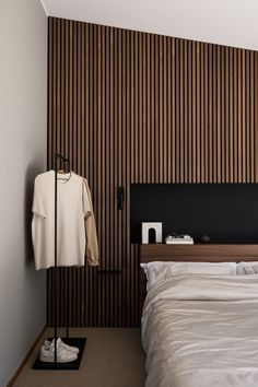 a white bed sitting next to a wooden wall