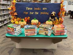 there are many books on the table in the library and one has a sign that says these books are ripe for the picking