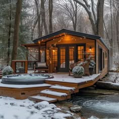 a hot tub sitting on top of a snow covered ground next to a wooden deck