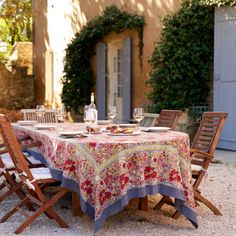 the table is set outside in front of an old building with ivy growing on it