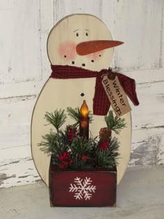 a wooden snowman with a red scarf and hat