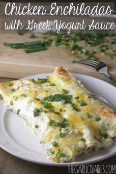 chicken enchiladas with greek yogurt sauce on a white plate next to a knife and fork