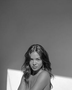 black and white photograph of a naked woman sitting on a chair with her legs crossed