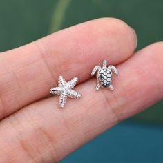 Mismatched Sea Turtle and Sea Star Stud Earrings in Sterling Silver, Silver or Gold, Asymmetric Starfish and Sea Turtle Earrings Sold as a pair.  Complete with sterling silver butterfly backs.   Materials and Care: These are made of sterling silver, and coated with Rhodium.  Only precious metals are used and they are hypoallergenic. Please keep in a sealed plastic bag when not wearing.  Packaging: All our jewellery comes with our branded velvet bag so your item is ready to be gifted.    Producti Beachy Earrings, Gold Earrings Models, Star Stud Earrings, Body Jewelry Piercing, Turtle Earrings, Helix Earrings, Sea Star, Star Earrings Stud, Silver Butterfly