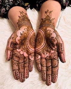 two hands with henna designs on them