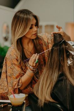 a woman cutting another woman's hair at a salon