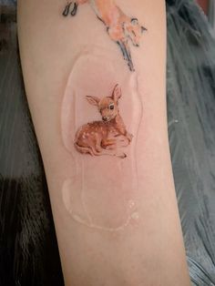 a small deer tattoo on the right arm