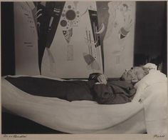 an old black and white photo of a man laying in bed