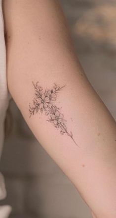 a woman's arm with a flower tattoo on the left side of her arm