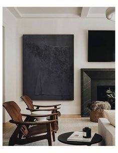 a living room filled with furniture and a painting hanging on the wall above a fire place