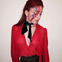 a woman with red hair and makeup has her face painted like a star wars character