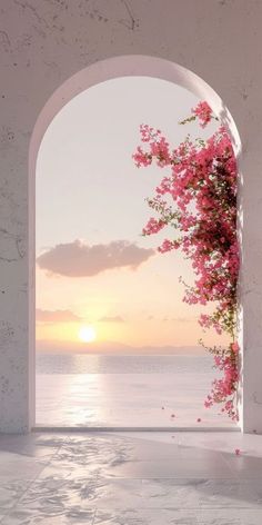 an open doorway with pink flowers on the wall and water in the background at sunset